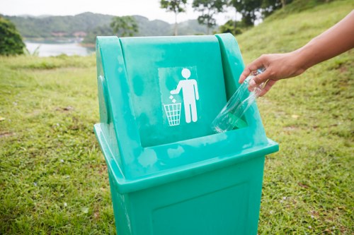 Business staff segregating waste into labelled recycling containers